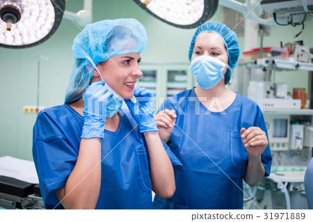 Female surgeon interacting with each other in corridor Female surgeon interacting with each other in corridor 31971889