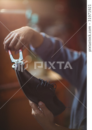 Shoemaker repairing a shoe 31971921
