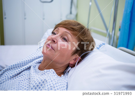 Sad senior patient lying on a bed 31971993