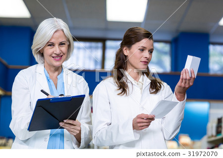 Pharmacists checking and writing prescription for medicine Pharmacists checking and writing prescription for medicine 31972070