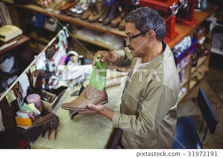 Shoemaker repairing a shoe sole 31972191