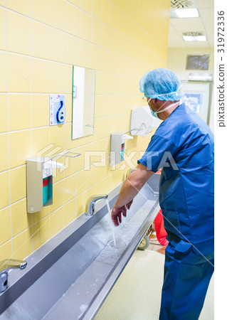Surgeon washing their hands at washbasin Surgeon washing their hands at washbasin 31972336