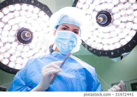 Female surgeon holding medical equipment in operating room 31972441