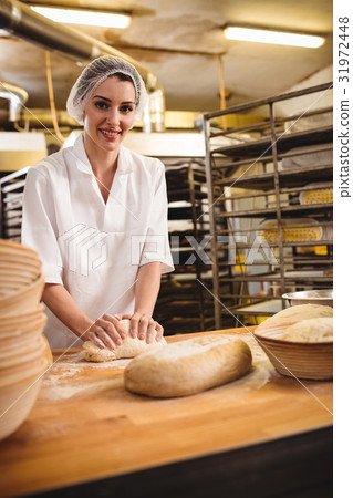 Female baker kneading a dough Female baker kneading a dough 31972448