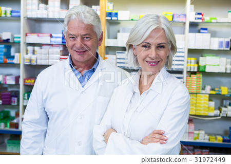 Smiling pharmacists standing in pharmacy Smiling pharmacists standing in pharmacy 31972449