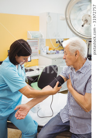 Female doctor checking blood pressure of patient 31972757