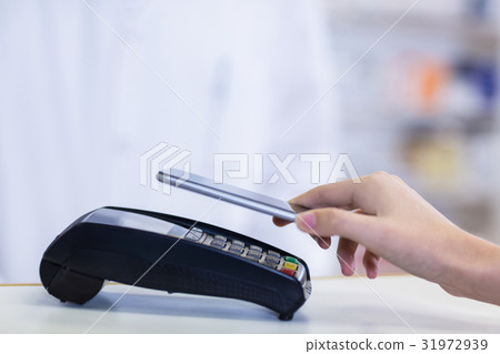 Woman paying bill through smartphone using NFC technology Woman paying bill through smartphone using NFC technology 31972939