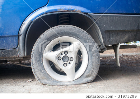 Deflated damaged tyre on car wheel. Deflated damaged tyre on car wheel. 31973299
