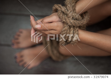 woman was tormented the the hands tied with a rope 31979074