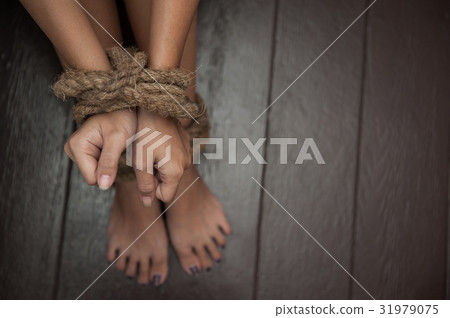 woman was tormented the the hands tied with a rope 31979075