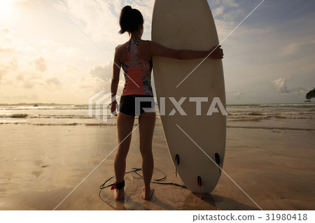 Young woman surfer with surfboard ready to surf Young woman surfer with surfboard ready to surf 31980418