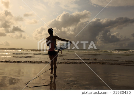Young woman surfer with surfboard ready to surf Young woman surfer with surfboard ready to surf 31980420