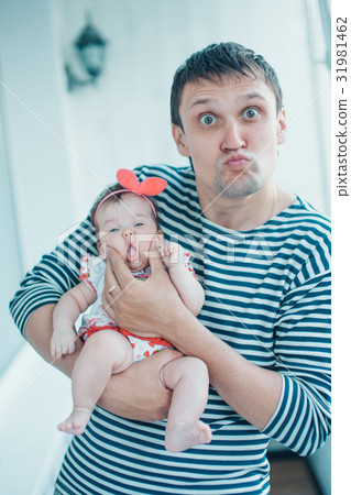 Father plays with a small daughter on a light Father plays with a small daughter on a light 31981462