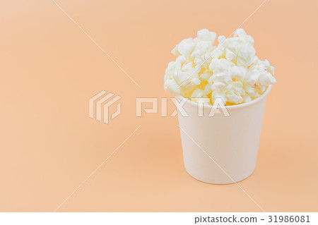 popcorn in a paper cup on orange background popcorn in a paper cup on orange background 31986081
