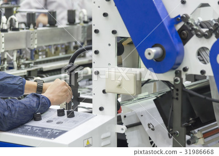 The technician adjust the printing machine. 31986668