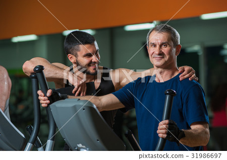 Happy senior man working with personal trainer Happy senior man working with personal trainer 31986697