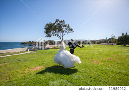 Couple smiling and embracing near wedding arch on Couple smiling and embracing near wedding arch on 31989912