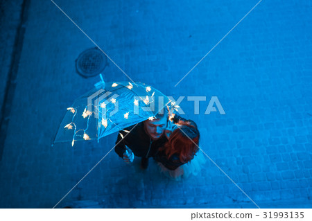 Guy and girl kissing under an umbrella Guy and girl kissing under an umbrella 31993135