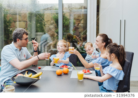 Happy family eating fresh fruit breakfast 31994376