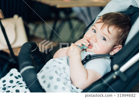 Little boy sitting in a baby carriage Little boy sitting in a baby carriage 31994682