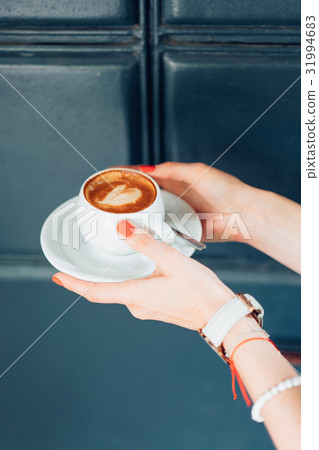 woman holding hot cup of coffee woman holding hot cup of coffee 31994683