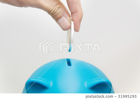 businessman hand putting a coin into piggy bank 31995293