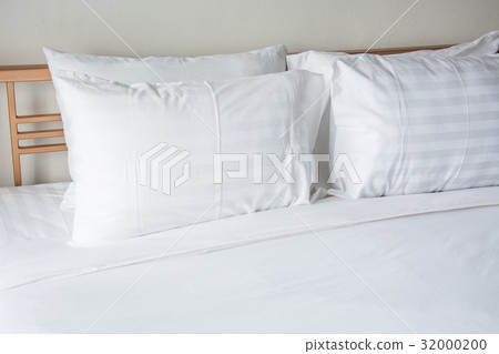 white pillow on bed with white blanket in bedroom 32000200