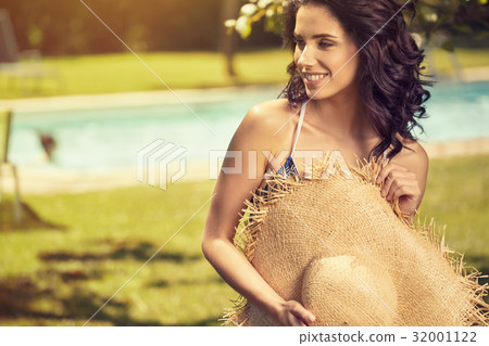 Woman on vacation by the pool 32001122