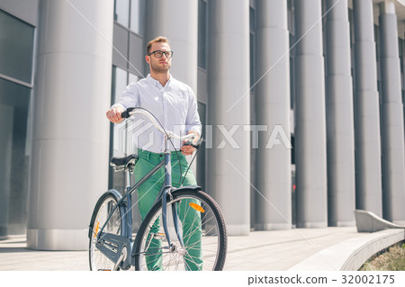 Cool young bearded hipster with bicycle on the 32002175