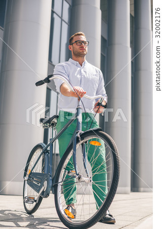 Cool young bearded hipster with bicycle on the Cool young bearded hipster with bicycle on the 32002176