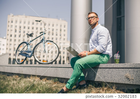 Business man with laptop and sport bike sitting in Business man with laptop and sport bike sitting in 32002183