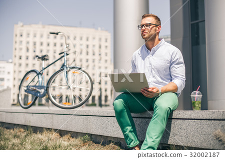 Business man with laptop and sport bike sitting in 32002187