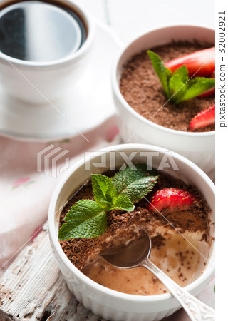 Tiramisu in the ramekins on the white table 32002921