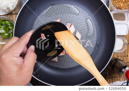 Chef putting slice of crab imitation to the pan 32004050