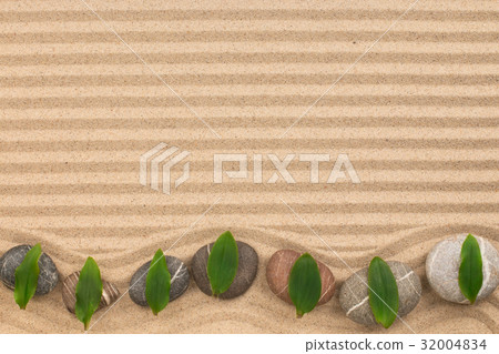 Frame of stones with green leaves zigzag on sand. 32004834