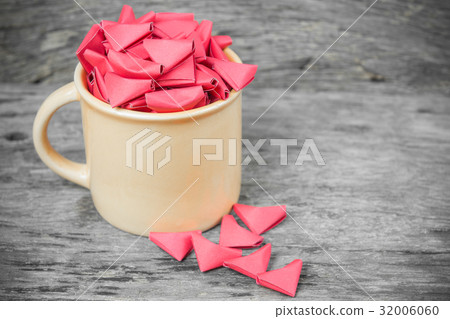 many red origami paper heart in orange ceramic cup 32006060