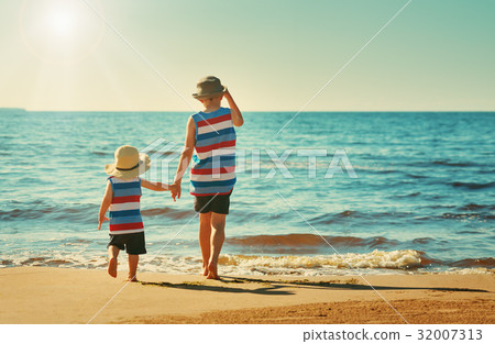 Two brothers are walking on the beach 32007313