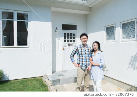 A couple standing in front of a house 32007376