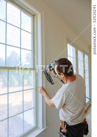 Carpenter brad using nail gun moldings on windows 32010241