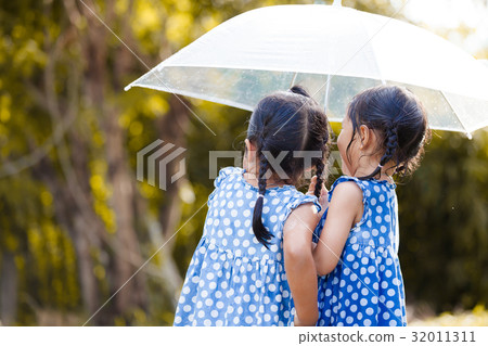 two asian girls with umbrella play with the rain two asian girls with umbrella play with the rain 32011311
