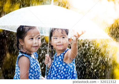 two asian girls with umbrella play with the rain 32011312