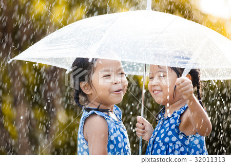 two asian girls with umbrella play with the rain 32011313