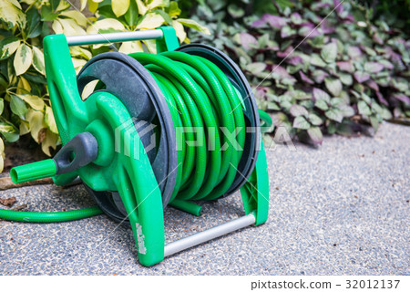 Roll the watering hose in the garden 32012137