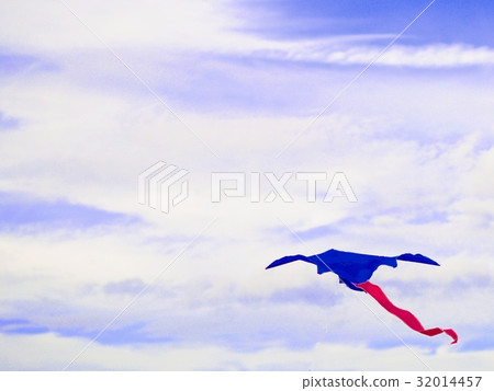 Kite blue with a red tail isolated on blurred sky. 32014457