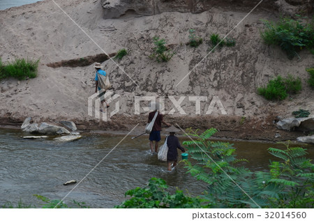 在老撾北部Nongkaru附近村莊的人們穿過村莊 在老撾北部Nongkaru附近村莊的人們穿過村莊 32014560