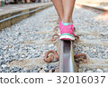 Woman walking on railroad tracks 32016037