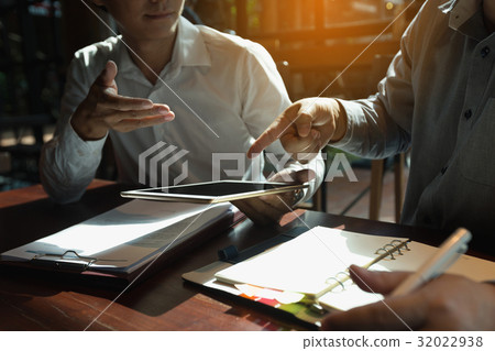 Two businessman using a digital tablet to discuss 32022938