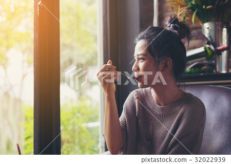 beautiful young woman eating something 32022939