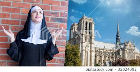 Young smiling nun standing near brick wall 32024392