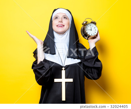 Young happy nun with alarm clock 32024405